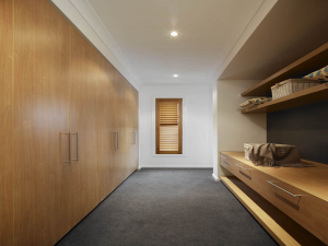 Exquisite wood grain and warm tones make the narrow walk-in wardrobe warm and relaxed